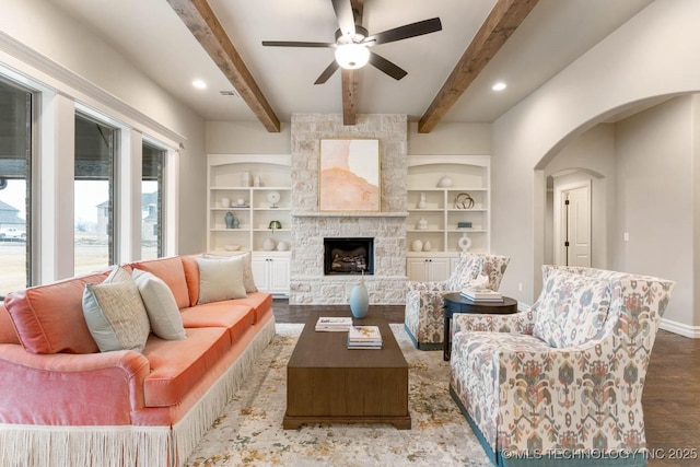 living room featuring hardwood / wood-style floors, a fireplace, built in features, and beamed ceiling