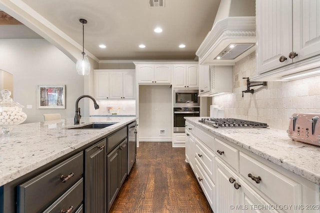 kitchen with sink, premium range hood, white cabinetry, stainless steel appliances, and light stone countertops