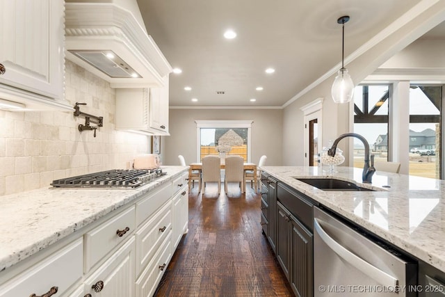 kitchen with sink, white cabinetry, decorative light fixtures, custom range hood, and stainless steel appliances