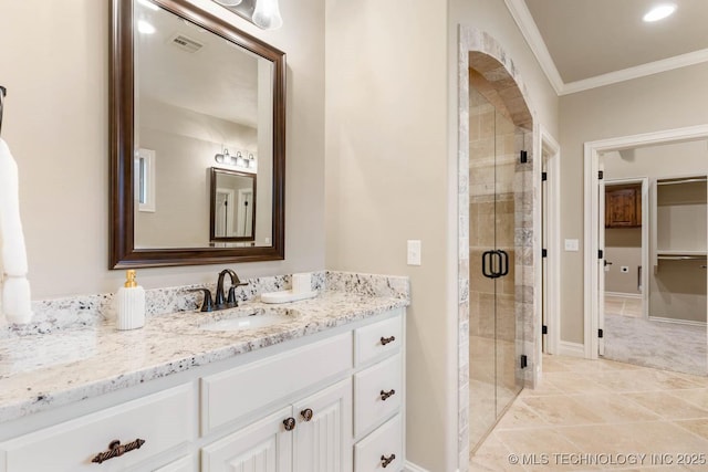 bathroom featuring ornamental molding, a shower with door, and vanity