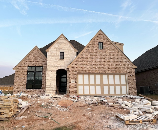 view of front of house featuring a garage and central air condition unit