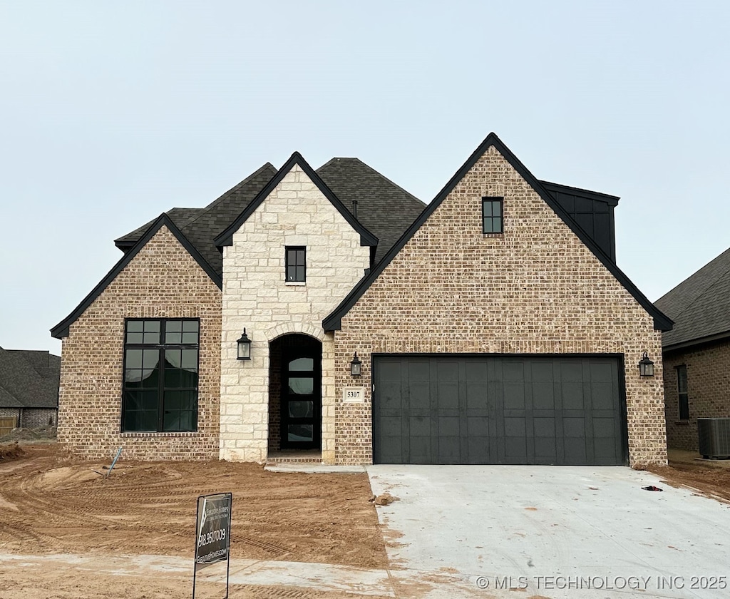 view of front of property with cooling unit and a garage