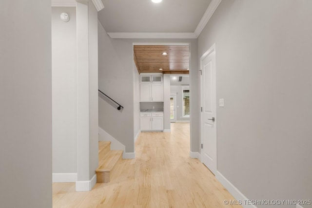 hallway with ornamental molding, light wood-style flooring, stairway, baseboards, and recessed lighting