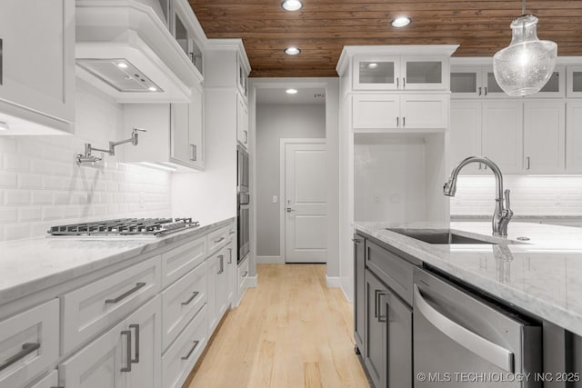 kitchen featuring stainless steel appliances, white cabinets, decorative light fixtures, recessed lighting, and light stone counters