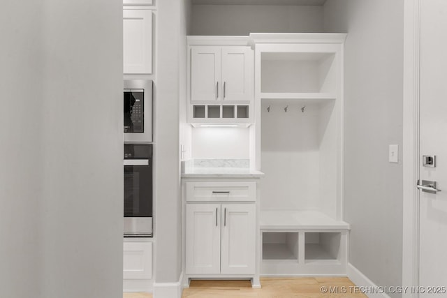 mudroom featuring light wood-style flooring and baseboards