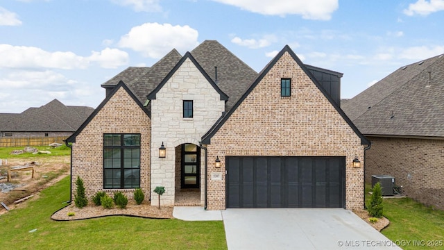 french country style house with concrete driveway, a front yard, brick siding, and a shingled roof