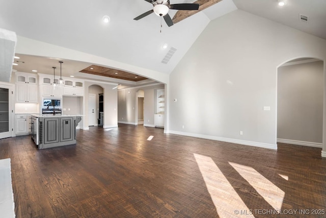 unfurnished living room featuring ceiling fan, dark hardwood / wood-style floors, and high vaulted ceiling