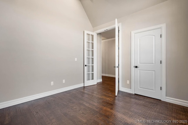 unfurnished bedroom featuring dark hardwood / wood-style flooring, french doors, and vaulted ceiling