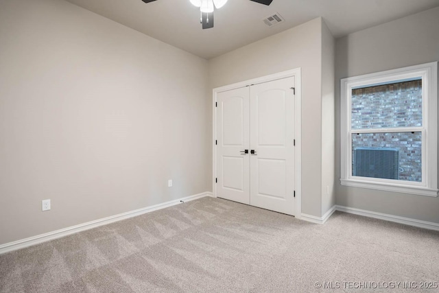 unfurnished bedroom featuring ceiling fan, a closet, and light colored carpet