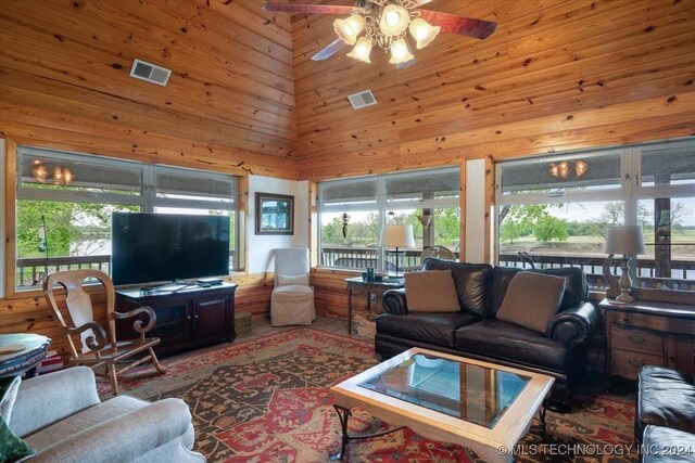 9212 N 447th Rd, Spavinaw, OK 74366 - living room featuring visible vents, ceiling fan, wooden walls, and a high ceiling