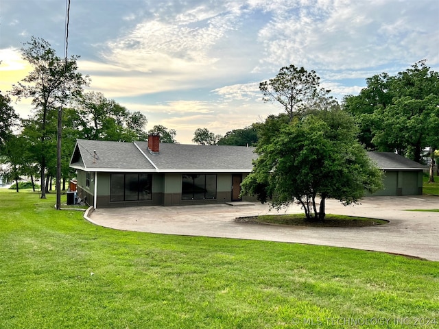 ranch-style home featuring cooling unit and a front yard