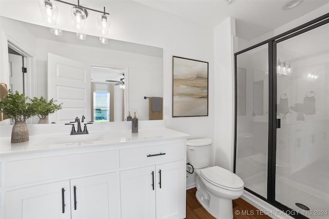 bathroom with vanity, walk in shower, toilet, and wood-type flooring