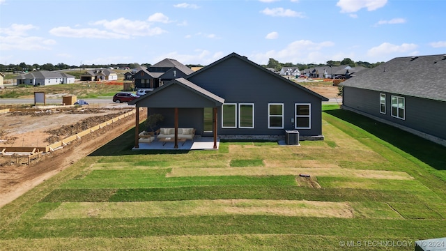 back of property with outdoor lounge area, a yard, and a patio area