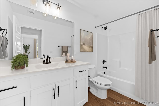 full bathroom with hardwood / wood-style floors, vanity, shower / bathtub combination, and toilet