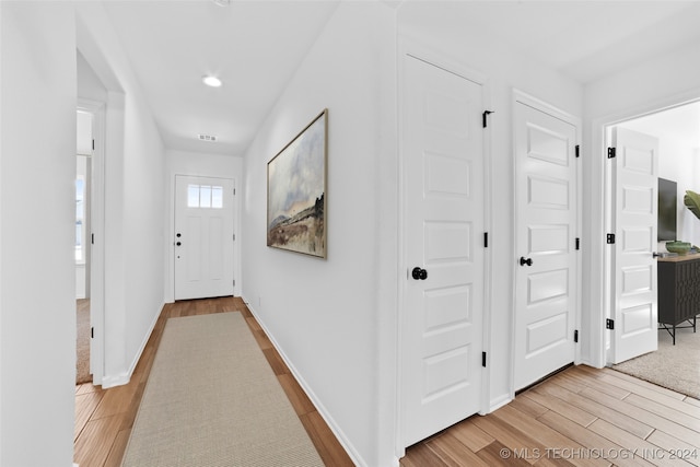 corridor with light hardwood / wood-style floors