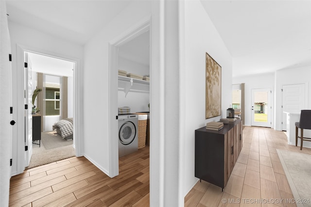 hall featuring light hardwood / wood-style flooring and washer / dryer