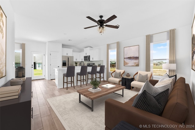 living room with lofted ceiling, light hardwood / wood-style floors, and ceiling fan