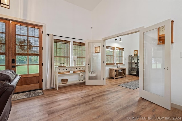 doorway to outside with light hardwood / wood-style flooring and a high ceiling