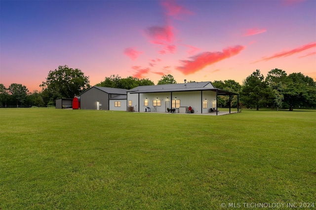 exterior space with a patio, an outdoor structure, and a lawn