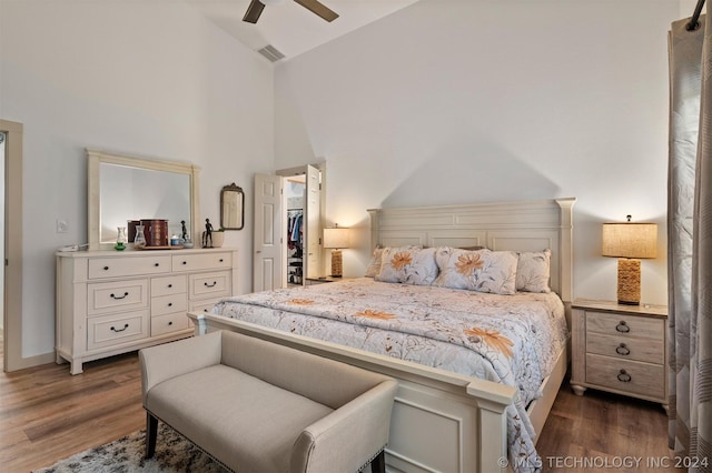 bedroom featuring dark wood-type flooring, ceiling fan, a spacious closet, a closet, and high vaulted ceiling