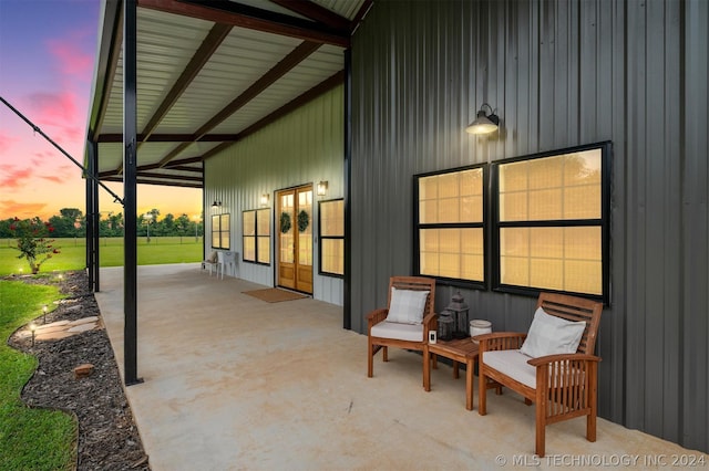 patio terrace at dusk featuring a yard