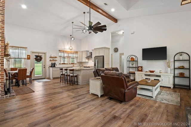 living room with wood-type flooring, a high ceiling, brick wall, and ceiling fan