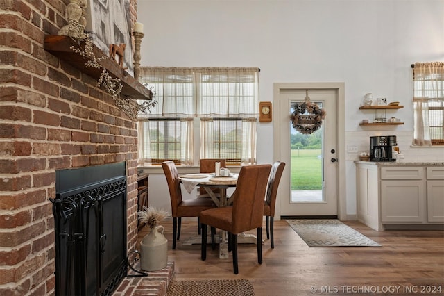 dining room featuring light hardwood / wood-style floors and a brick fireplace