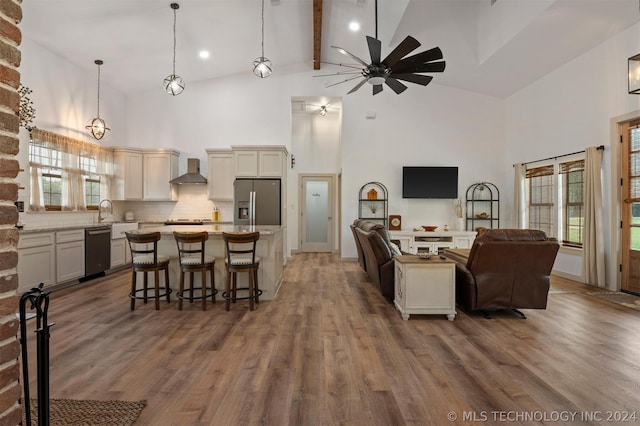 living room featuring ceiling fan, beamed ceiling, hardwood / wood-style flooring, and high vaulted ceiling