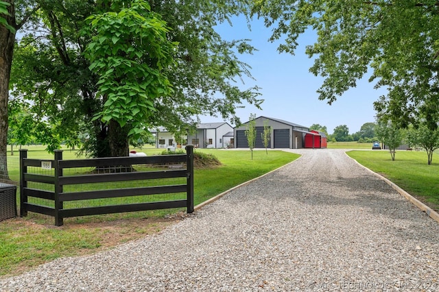 exterior space with a garage, an outdoor structure, and a front lawn