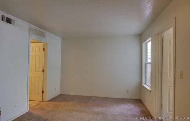 unfurnished room with light carpet