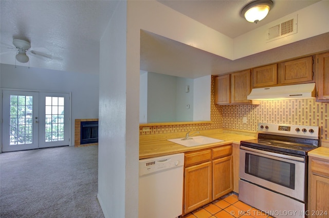 kitchen with sink, tasteful backsplash, light carpet, electric range, and dishwasher