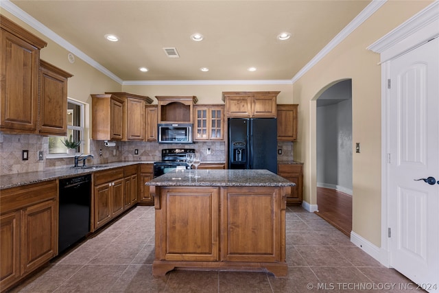 kitchen featuring dark wood-type flooring, black appliances, dark stone counters, and a center island