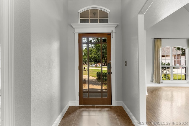entryway featuring a textured wall, tile patterned flooring, and baseboards