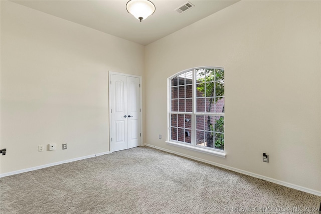 carpeted empty room featuring visible vents and baseboards