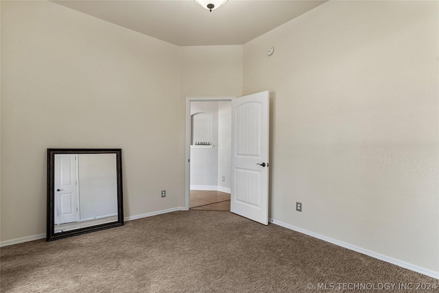 unfurnished room with carpet and baseboards