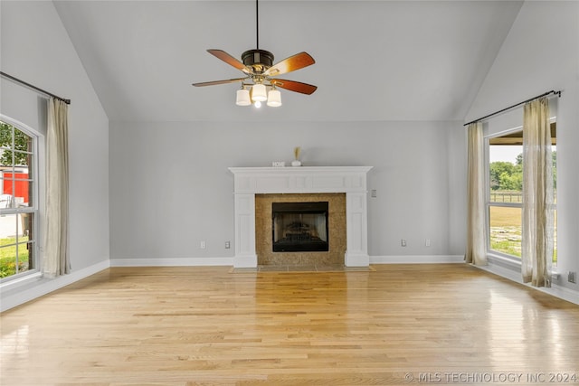 unfurnished living room with a fireplace, a healthy amount of sunlight, ceiling fan, and light wood-style floors