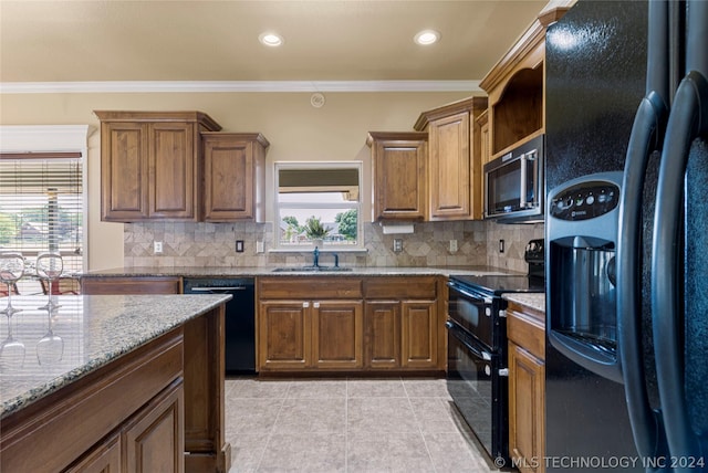 kitchen featuring black appliances, ornamental molding, decorative backsplash, and a sink