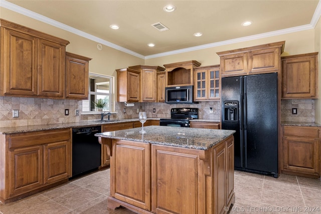 kitchen featuring a center island, black appliances, brown cabinets, and a sink