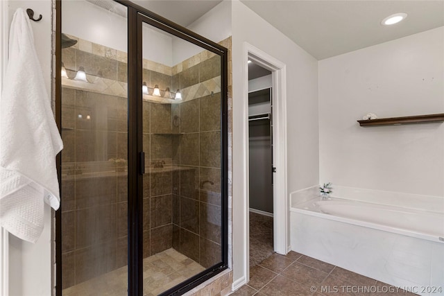full bath with a bath, a stall shower, baseboards, tile patterned flooring, and a spacious closet