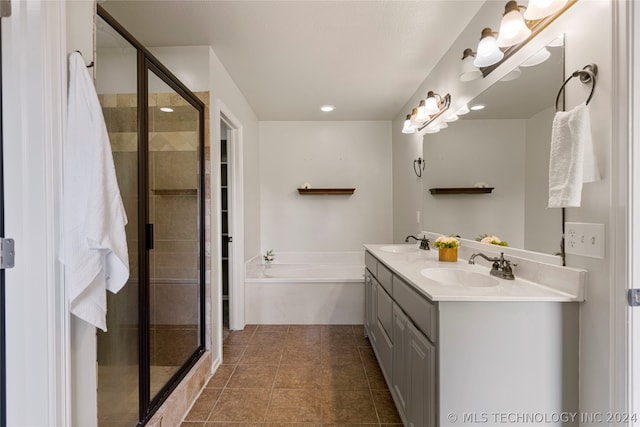 bathroom with tile patterned flooring, separate shower and tub, and dual vanity