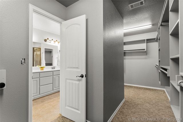 walk in closet featuring visible vents and light colored carpet