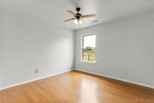 spare room with baseboards, visible vents, ceiling fan, and light wood-style floors