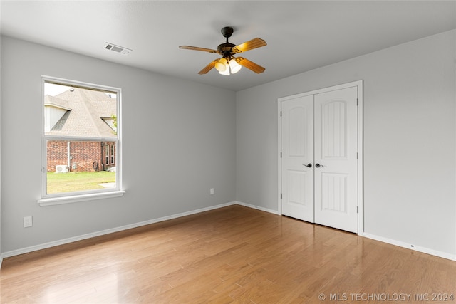 unfurnished bedroom with light hardwood / wood-style floors, a closet, and ceiling fan