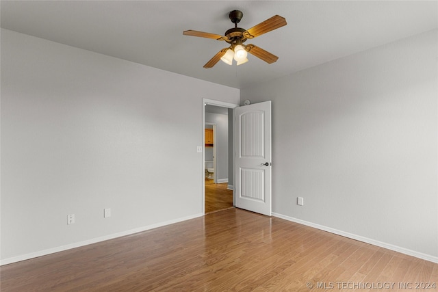 empty room with baseboards, wood finished floors, and a ceiling fan