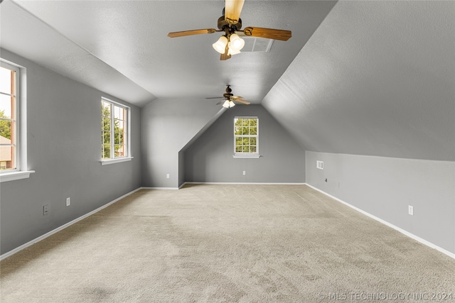 bonus room with plenty of natural light, light carpet, ceiling fan, and vaulted ceiling