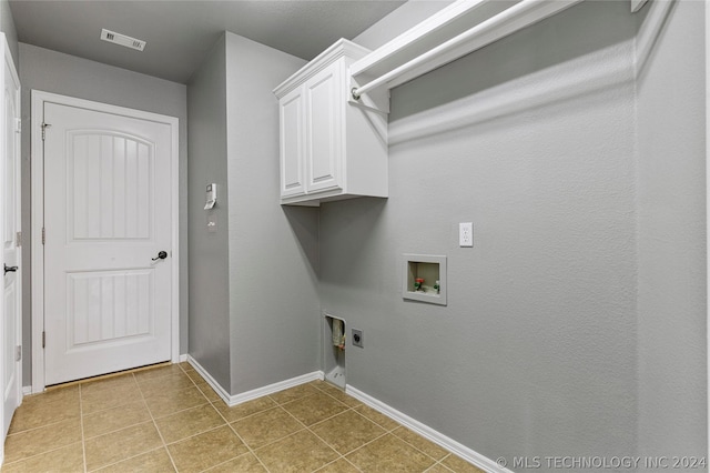 clothes washing area with hookup for an electric dryer, cabinet space, washer hookup, visible vents, and baseboards
