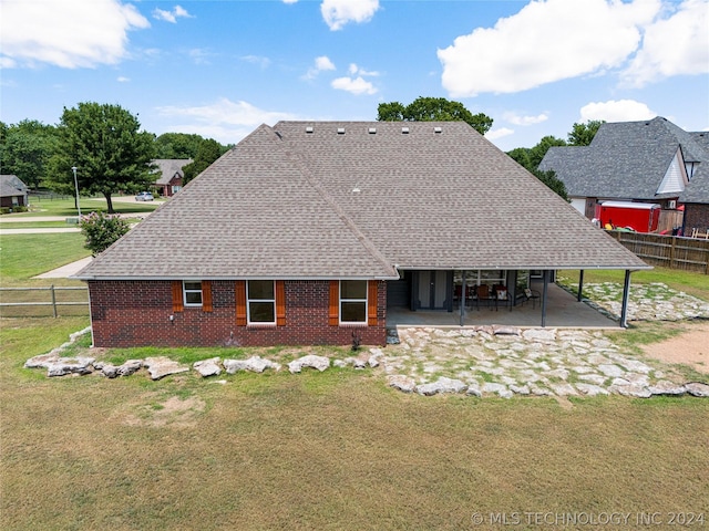 back of property with a patio, brick siding, fence, and a yard