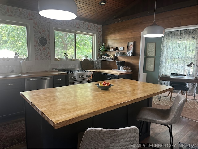 kitchen featuring lofted ceiling, decorative light fixtures, dark wood-type flooring, stainless steel appliances, and wooden ceiling