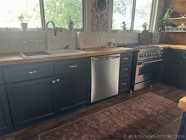 kitchen with stainless steel appliances, tasteful backsplash, dark wood-type flooring, and sink