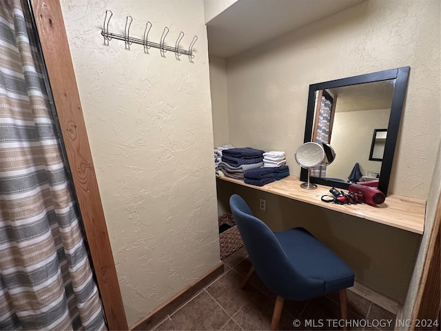 home office with built in desk and dark tile patterned floors